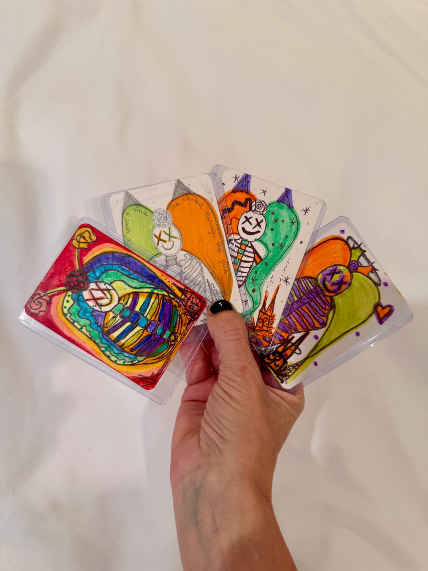 Four finished Skeleton Psychosis artist trading cards held in one hand