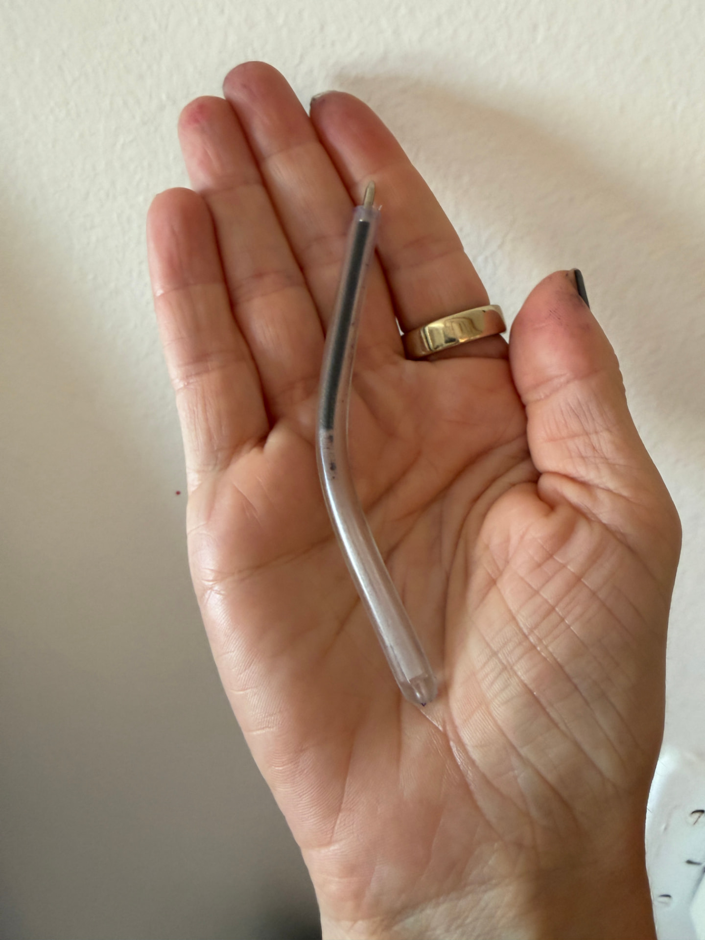 The bendable safety pen resting across an open palm for scale